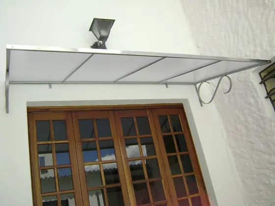 Toldo em policarbonato com suporte de ferro sobre janela